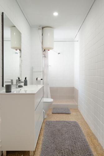 a white bathroom with a sink and a toilet at Claudius Mare in Gandía