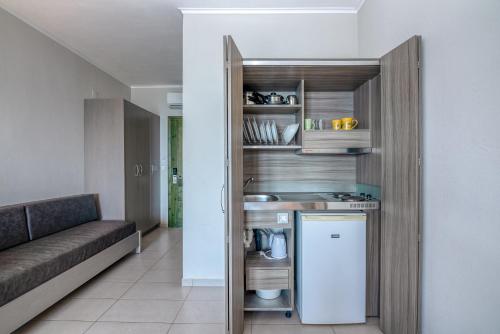 a kitchen with a refrigerator and a couch in a room at Christina Beach Hotel in Kissamos