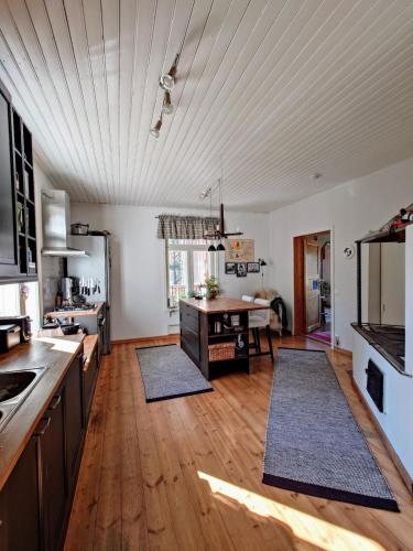 a kitchen with wooden floors and a table with two rugs at Perfect spot to enjoy in Pargas