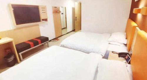 a hotel room with two beds and a flat screen tv at 7 Days Premium Hotel Ji'an Taihe Gongnongbing Avenue in Ji'an