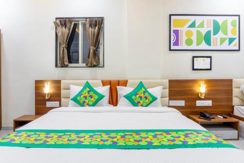 a bedroom with a large white bed with colorful pillows at Treebo Aura Inn Regency in Pune