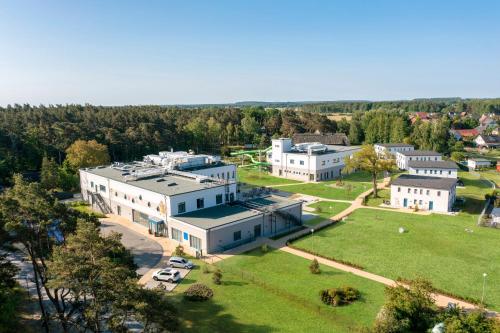トラッセンハイデにあるTUI SUNEO Kinderresort Ihr entspannter Familienurlaub mit Abenteuerspielplatz & der längsten Wasserrutsche im deutschen Teil der Insel Usedomの公園付きの大きな建物の空中ビュー