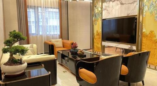 a living room with a large television and a living room at Chaozhou Hotel in Chaozhou