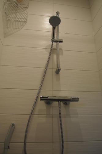 a shower with a hose hooked up to a wall at Männi Holiday House in Haapsalu