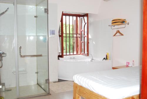 a bathroom with a shower and a tub and a bed at A1 Hotel - Dien Bien Phu in Diện Biên Phủ