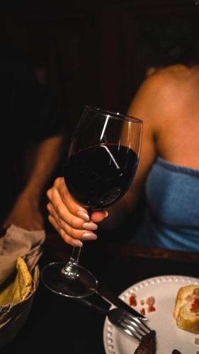 a woman is holding a glass of red wine at Suites H la ermita in San Miguel de Allende