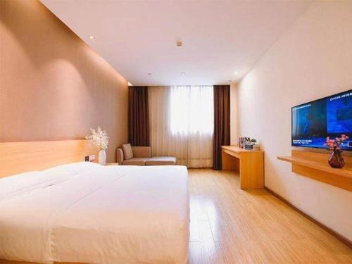 a bedroom with a large bed and a flat screen tv at 7 Days Premium Chongqing Longtou Temple North Railway Station Center in Chongqing