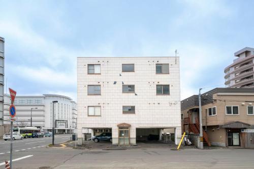 a white brick building on the corner of a street at Silk Court 301 in Chitose