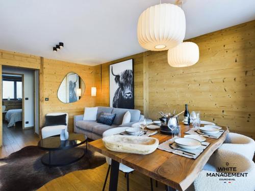 un salon avec une table et un canapé dans l'établissement Résidence Ariondaz DaphnÉe - Appartement traversant avec magnifique vue Vallée MAE-4624, à Courchevel
