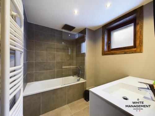 une salle de bain avec une douche, une baignoire et un lavabo dans l'établissement Résidence Ariondaz DaphnÉe - Appartement traversant avec magnifique vue Vallée MAE-4624, à Courchevel