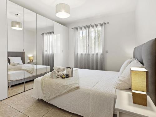 une chambre blanche avec un lit et un miroir dans l'établissement Villa 150m2, Piscine, Parking, Wifi, Clim, à Saint-Raphaël