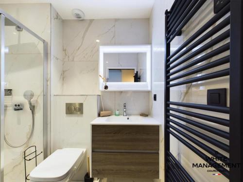 une salle de bain avec un lavabo, des toilettes et une douche dans l'établissement Résidence Ariondaz Anemone - Penthouse familial skis aux pieds MAE-4724, à Courchevel