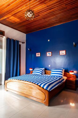 a blue bedroom with a bed with blue walls at Maison Ubururu in Kigali