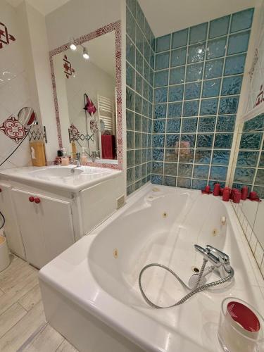 a bathroom with a tub and a sink and a mirror at L'appart de Coco - Idéal pour découvrir Cassis in Cassis