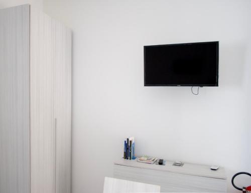 a living room with a tv on a white wall at A due passi dal mare - Oasi di pace in Petacciato