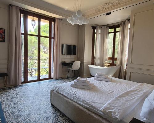 une chambre avec un lit, une baignoire et une télévision dans l'établissement Villa La Joè, à Cannes