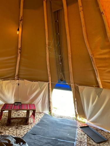 a tent with a table inside of it at Thainstone tipi off grid camping, on top NC500 in Lochcarron