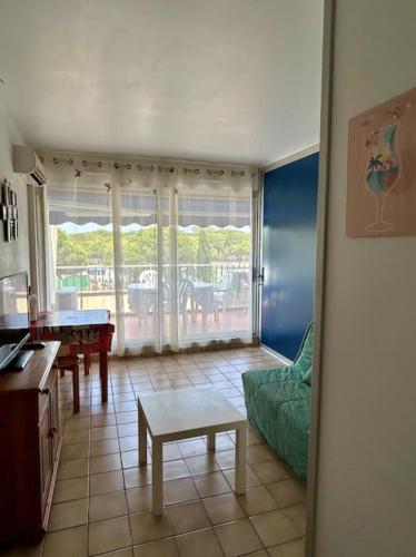 un salon avec un canapé et une table dans l'établissement 50m avec Terrasse dans une résidence avec PISCINE, au Grau-du-Roi