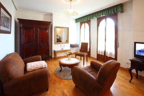 a living room with chairs and a table and a tv at Hotel Merindad de Olite in Olite