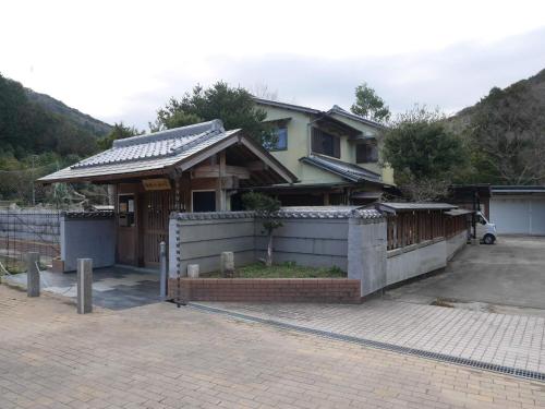 a house with a fence in front of it at 横輪弘法の宿 in Ise