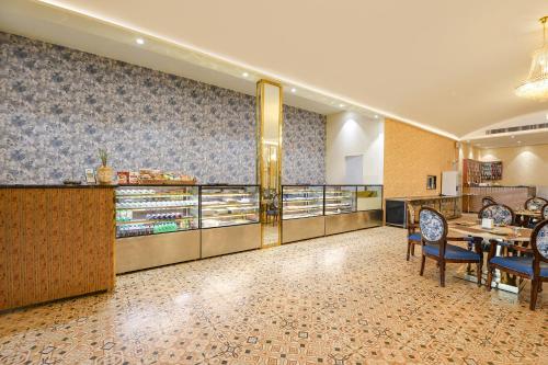 a restaurant with a counter and a table and chairs at Oriva Ganeshwaram 149 in Greater Noida