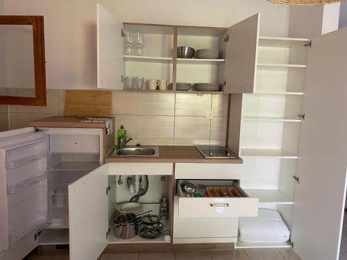 a kitchen with white cabinets and a sink at Villa Maslinica in Maslinica