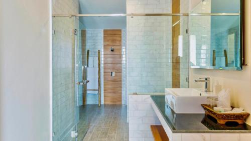 a bathroom with a sink and a glass counter at Aura Samui Best Beach Hotel - SHA Plus in Lamai