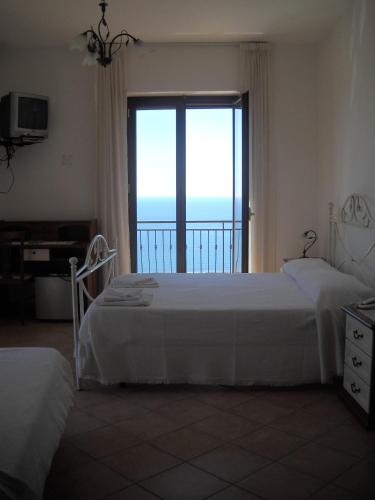 a bedroom with two beds and a view of the ocean at Villa Malandrino Guest House in Agropoli