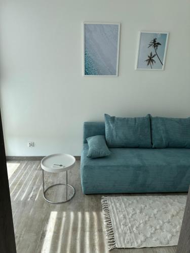 a living room with a blue couch and a table at Morze, Basen&SPA i Spokój Apartament 2 Pięć Mórz w Sianożętach in Sianozety
