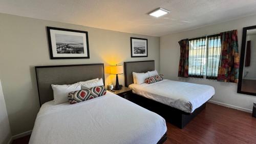 a hotel room with two beds and a window at Budget Motel in Gilroy