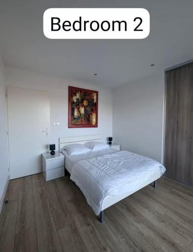 une chambre avec un lit et un tableau au mur dans l'établissement Le Courant - 3 Chambres avec une vue imprenable, à Mimizan-Plage