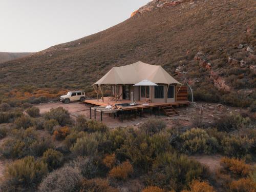 a tent in the middle of a field with a mountain at Elements Luxury Tent in Goedgemond