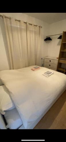 - une chambre avec un lit blanc et des rideaux blancs dans l'établissement Au cœur de Nîmes, un appart lumineux où il fait bon vivre, à Nîmes
