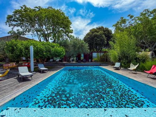 une piscine avec de l'eau bleue dans une cour dans l'établissement La Loggia, Bastide contemporaine avec piscine au coeur du Luberon, à Saint-Saturnin-lès-Apt