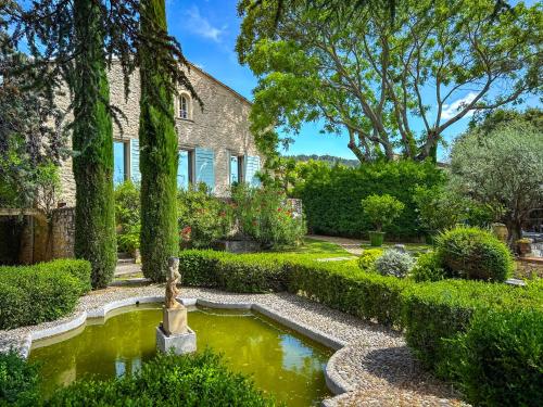 un jardin avec une fontaine en face d'une maison dans l'établissement La Loggia, Bastide contemporaine avec piscine au coeur du Luberon, à Saint-Saturnin-lès-Apt