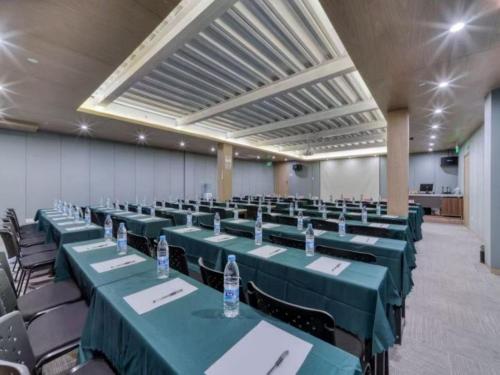 a large room with green tables and chairs at 唯庭世纪酒店上海静安火车站店 in Shanghai