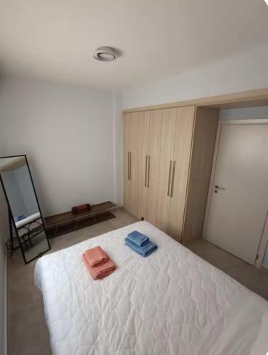 a bedroom with a white bed with two towels on it at Joanna s apartment in Petalidi