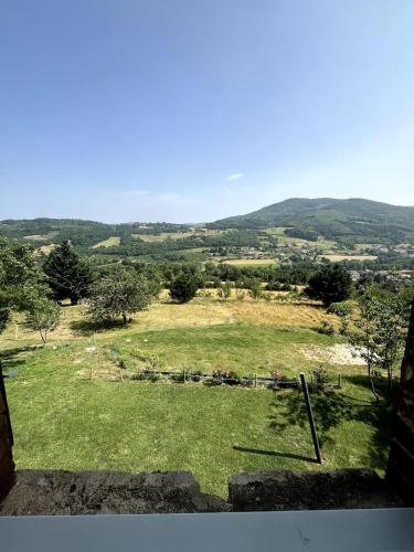a view of a field of grass with mountains in the background at Gite à la ferme, Domaine Solio in Satillieu