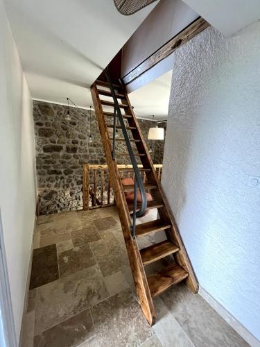 a staircase in a room with a stone wall at Gite à la ferme, Domaine Solio in Satillieu