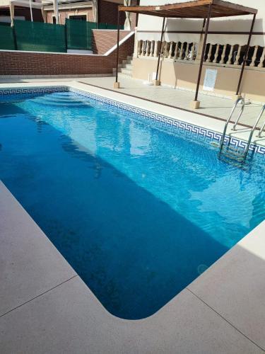 a swimming pool with blue water in a building at El Chalét de Manolo in Aljaraque
