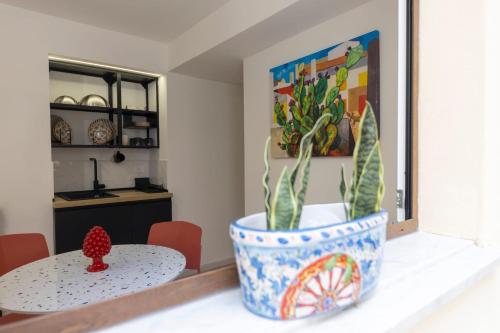 a room with a table and a pot with a plant at Casa Zio Lele in Cefalù