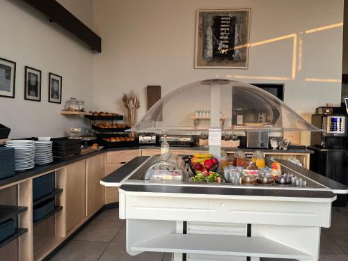 Una cocina con una encimera con comida encima. en Cit'Hotel Les Eleis, en Saint-Martin-de-Fraigneau