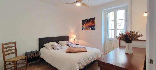 a bedroom with a bed and a chair and a window at Le Petit Clos - Village house in Saint-Geniès in Saint-Geniès