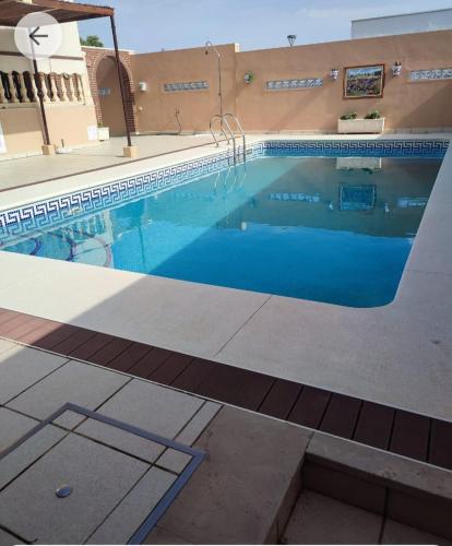 a swimming pool with blue water in a building at El Chalét de Manolo in Aljaraque
