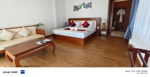 a hotel room with a bed and a couch at Aura Samui Best Beach Hotel - SHA Plus in Lamai