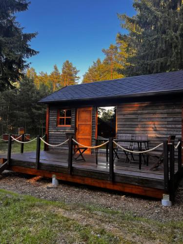 a log cabin with a picnic table on the deck at Chaloupka na jehličí in Všelibice