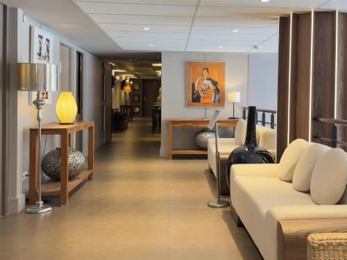 a living room with a couch and a table at Golden Tulip Villepinte Roissy - Parc des Expositions in Roissy-en-France
