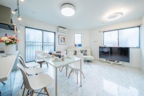 a living room with a white table and chairs at QiQi House Tokyo まるごと新築一軒家宿 Spacious New Home, 8 Guests, Easy Airport & Disney Access in Tokyo