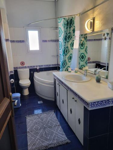 a bathroom with a sink and a tub and a toilet at Villa Paradies in Káto Lekhónia