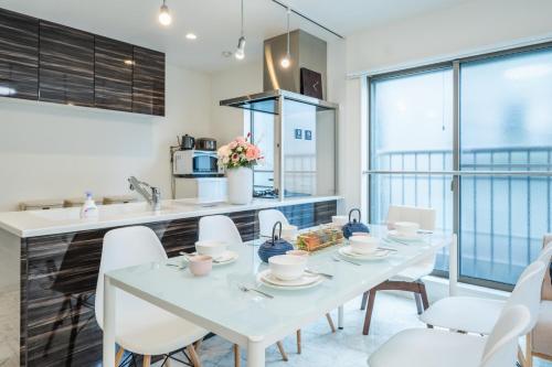 a kitchen with a white table and white chairs at QiQi House Tokyo まるごと新築一軒家宿 Spacious New Home, 8 Guests, Easy Airport & Disney Access in Tokyo